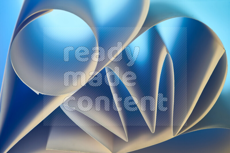 An artistic display of paper folds creating a harmonious blend of geometric shapes, highlighted by soft lighting in blue and warm tones