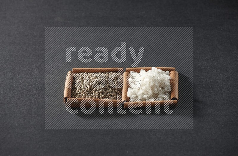 2 squares of cinnamon sticks full of white pepper and salt on black flooring