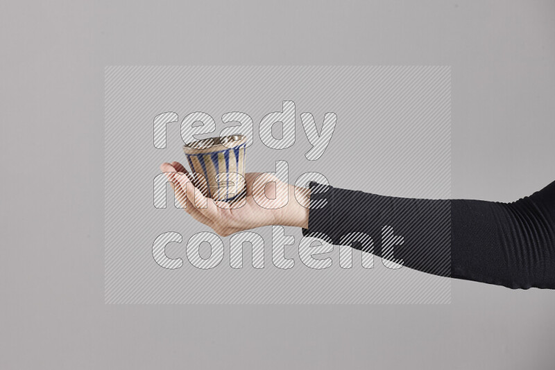 A woman in black abaya holding different pottery essentials in different positions
