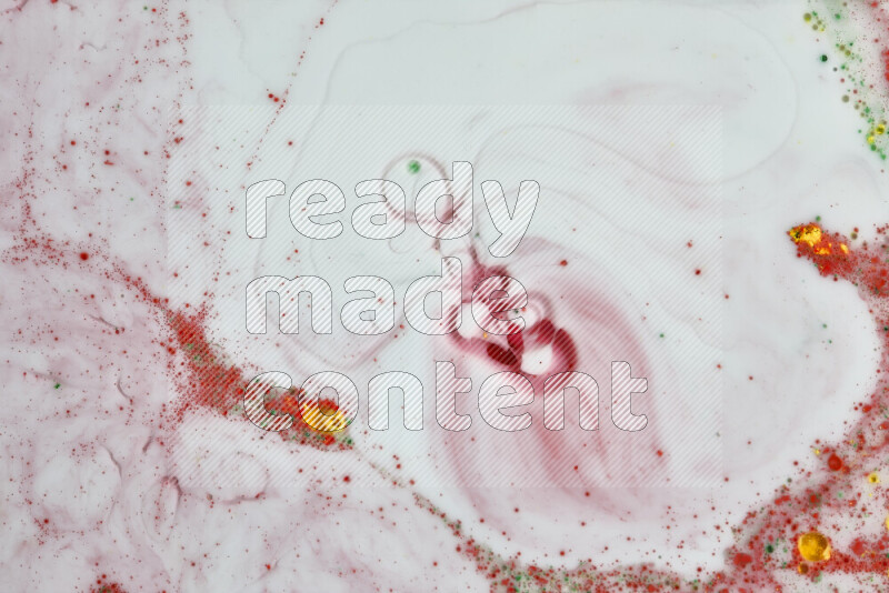 The image captures a splatter of yellow, red and green paint over a white backdrop
