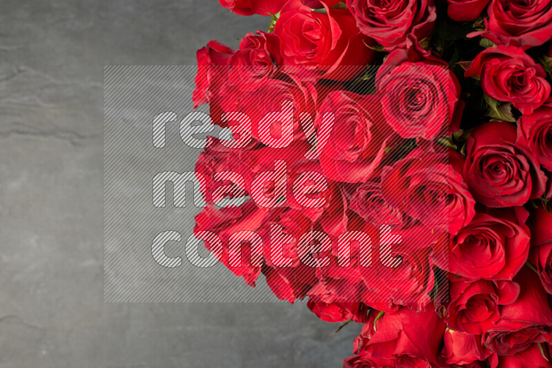 A luxurious bouquet of red roses on black marble background