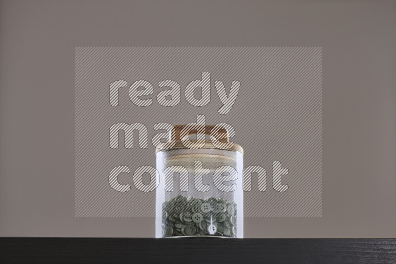 Buttons in a glass jar on black background