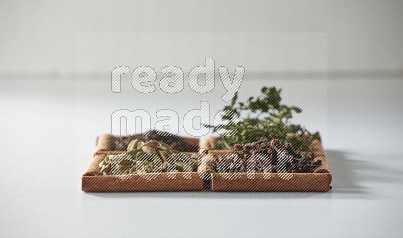 4 squares of cinnamon sticks full of tea, cardamom, mint and cloves on white flooring