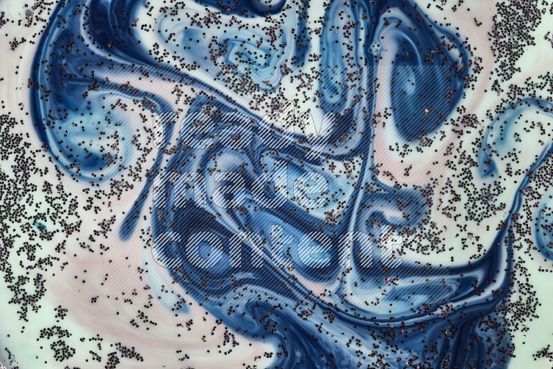 A close-up of sparkling purple glitter scattered on swirling green, red and blue background