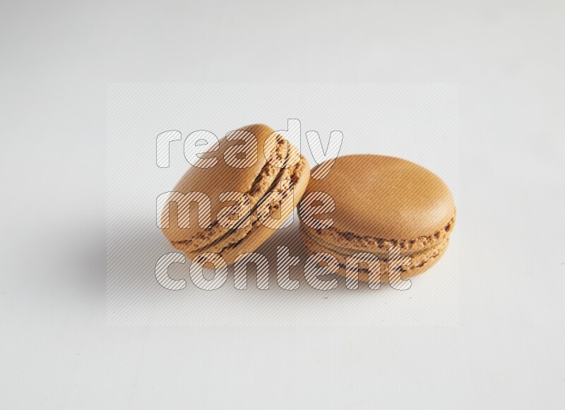45º Shot of two Brown Maple Taffy macarons on white background