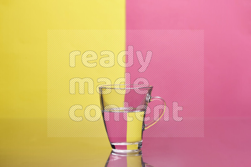 The image features a clear glassware filled with water, set against yellow and pink background