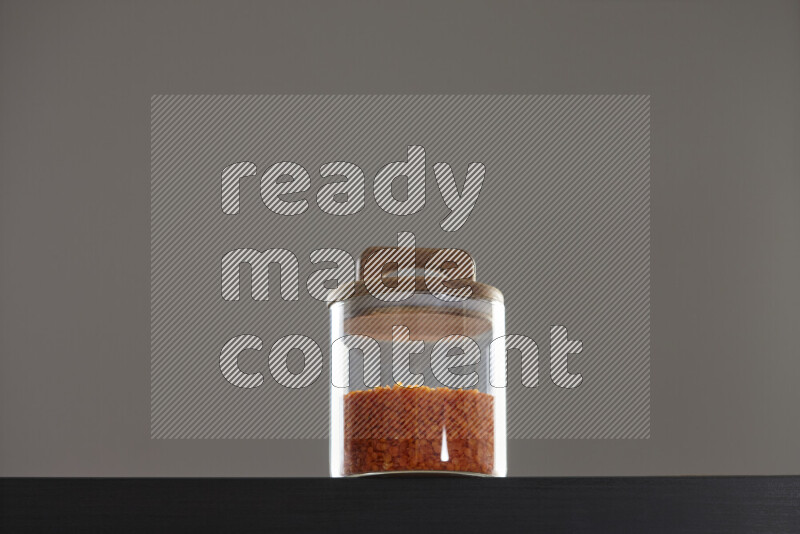 Lentils in a glass jar on black background