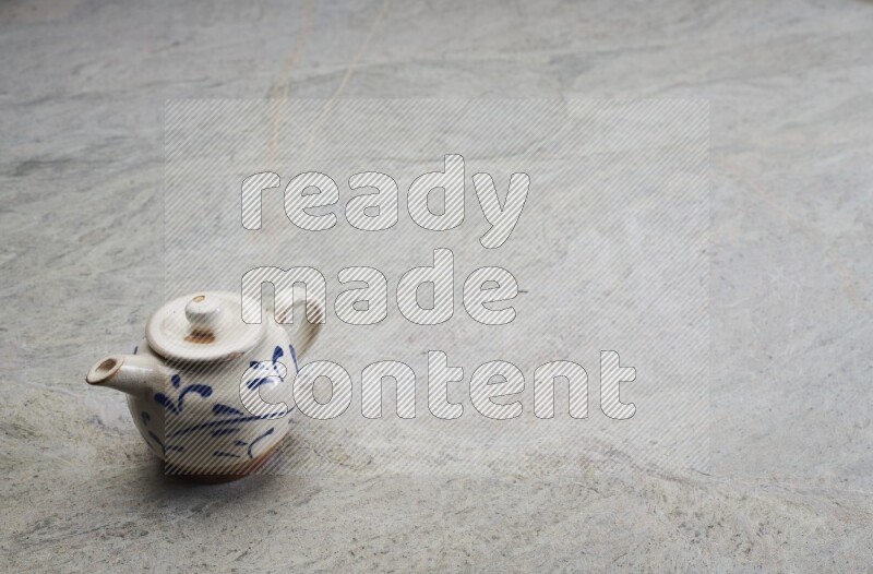 A pottery teapot on grey marble background