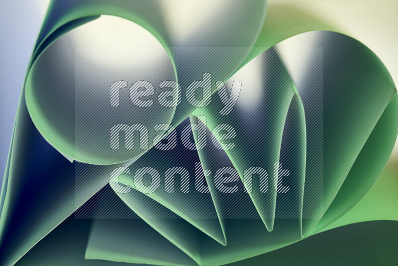 An artistic display of paper folds creating a harmonious blend of geometric shapes, highlighted by soft lighting in green tones