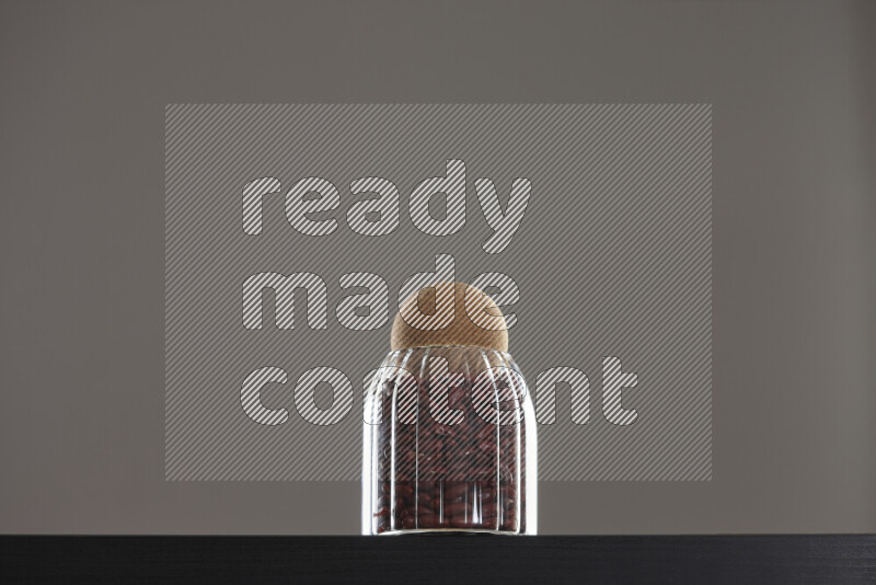 Red kidney beans in a glass jar on black background