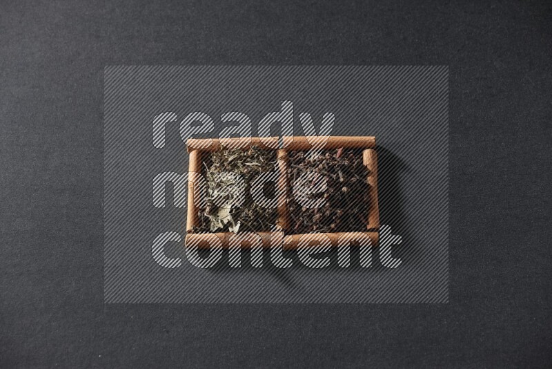 2 squares of cinnamon sticks full of cloves and dried basil on black flooring