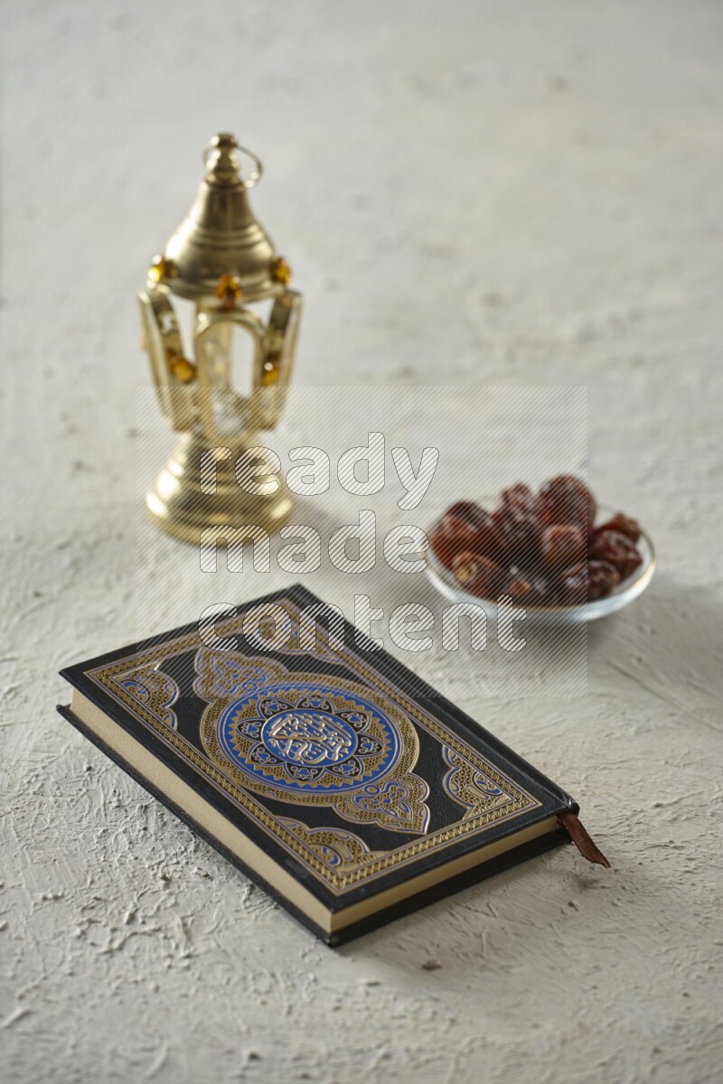 A golden lantern with different drinks, dates, nuts, prayer beads and quran on textured white background