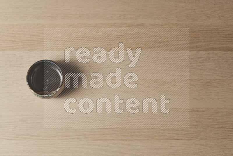 وعاء فخاري متعدد الألوان على خلفية خشبية فاتحة