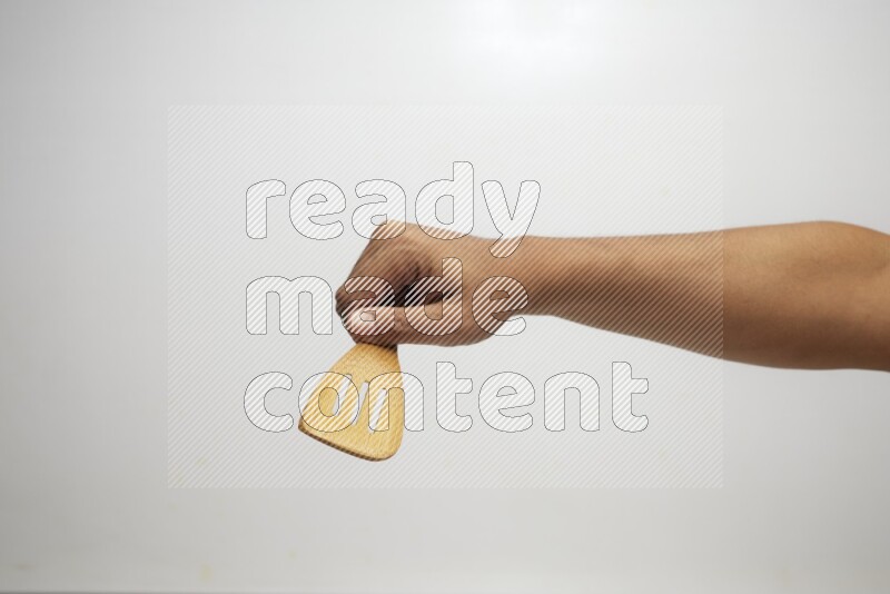 Male Hand Holding Slotted Turner on white background