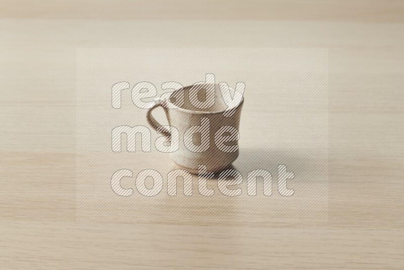 A pottery cup on light wooden background