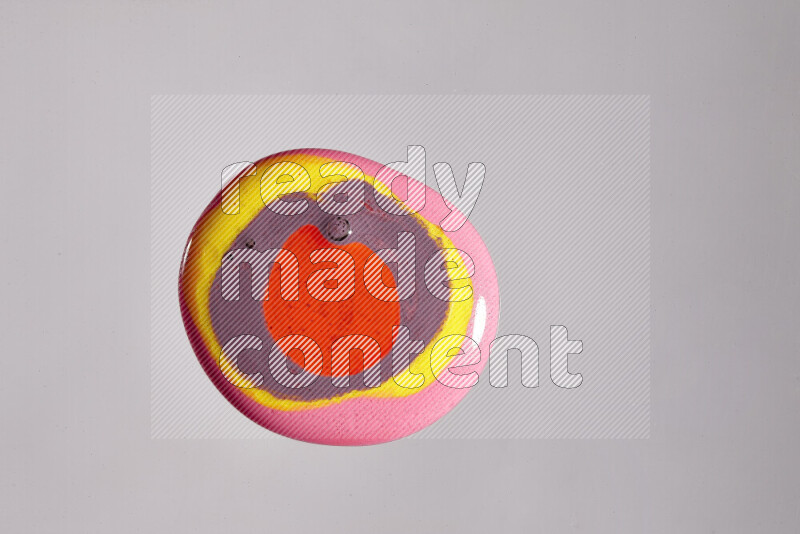 لقطات مقربة لألوان متنوعة تمتزج على خلفية رمادية