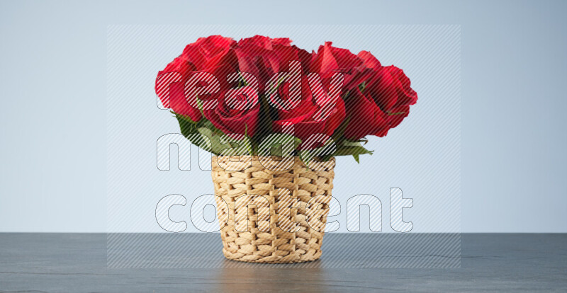 Vibrant red roses in a wicker basket on black marble background