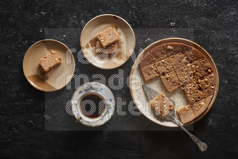 بسبوسة مع الشاي علي خلفية سوداء خشبية