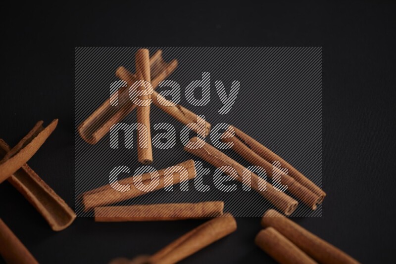 Cinnamon sticks stacked on black flooring