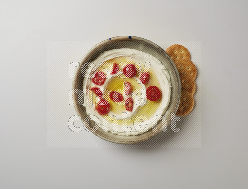 Lebnah garnished with cherry tomato in a grey pottery plate on a white background