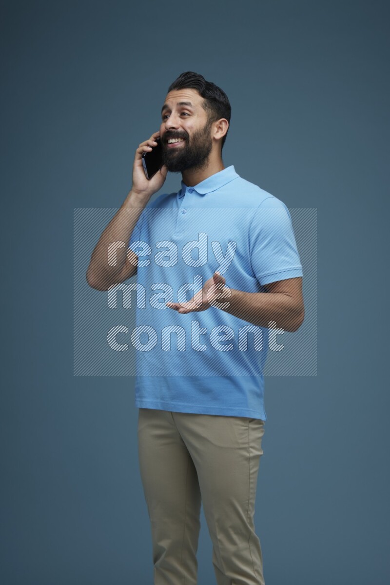 A man having a Call in a blue background wearing a Blue shirt