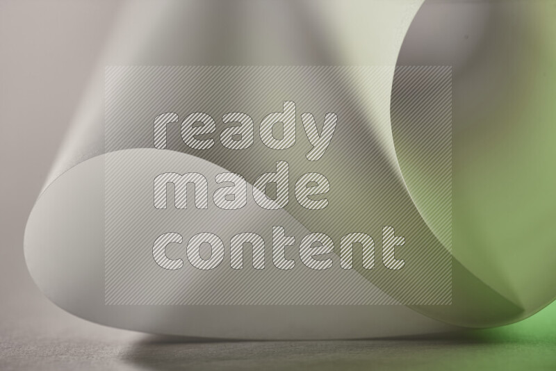 An abstract art piece displaying smooth curves in green and grey gradients created by colored light