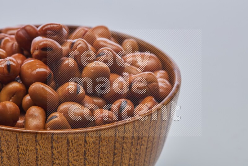Close up shot of cooked fava beans (foul) in a container on white background