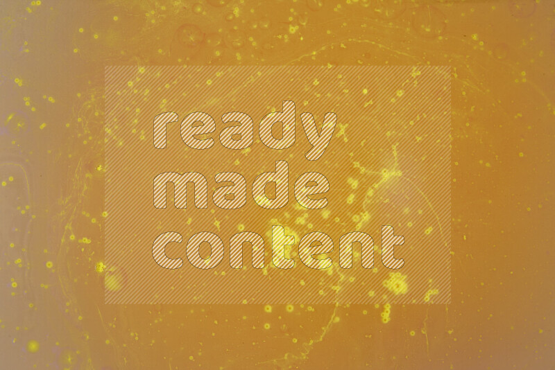 The image captures a dramatic splatter of yellow paint over a white backdrop