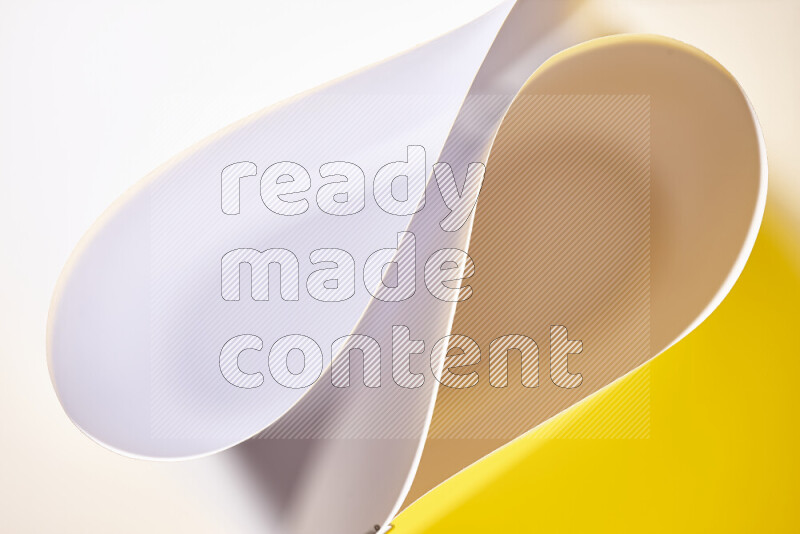 An abstract art of paper folded into smooth curves in white and yellow gradients