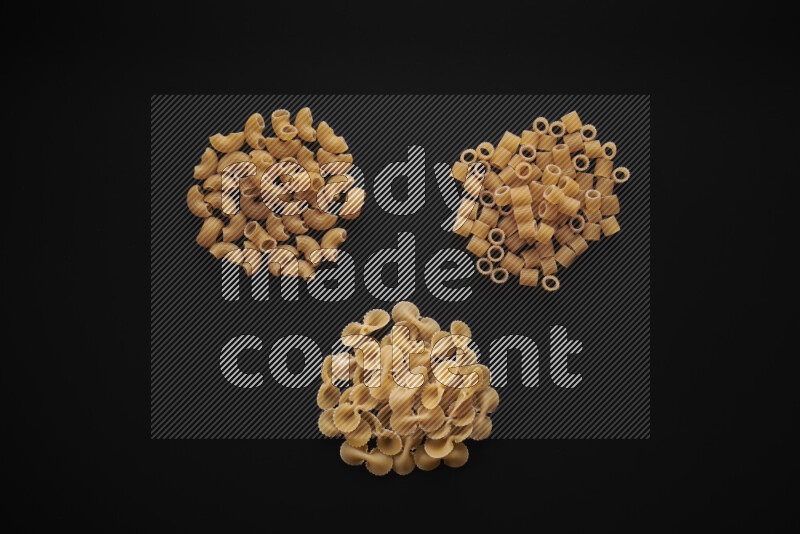 Different pasta types in bunches on black background