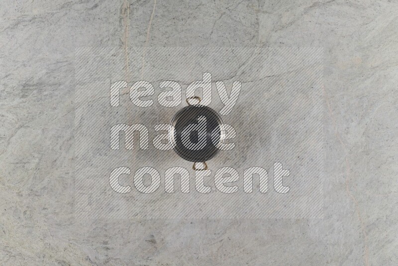 A small copper pot on grey marble background