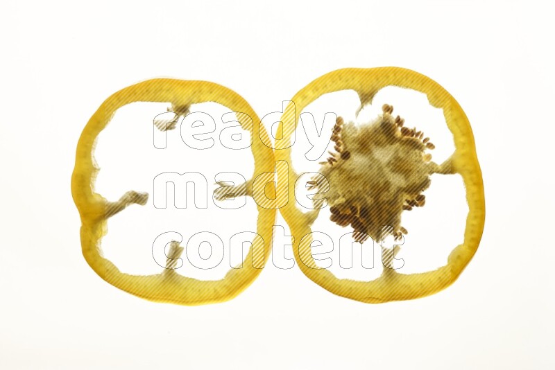 Yellow bell pepper slices on illuminated white background