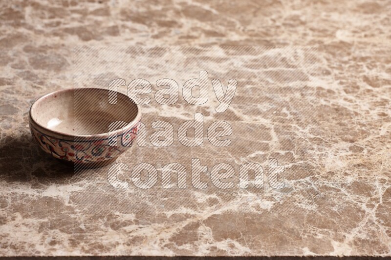 A decorative pottery bowl on beige marble background