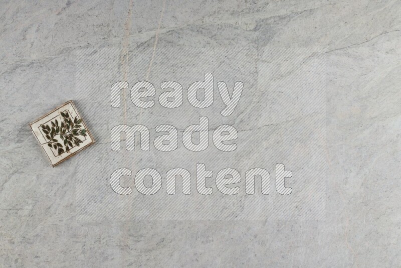 A decorative pottery coaster on grey marble background