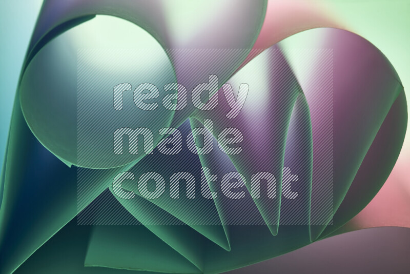 An artistic display of paper folds creating a harmonious blend of geometric shapes, highlighted by soft lighting in green and pink tones