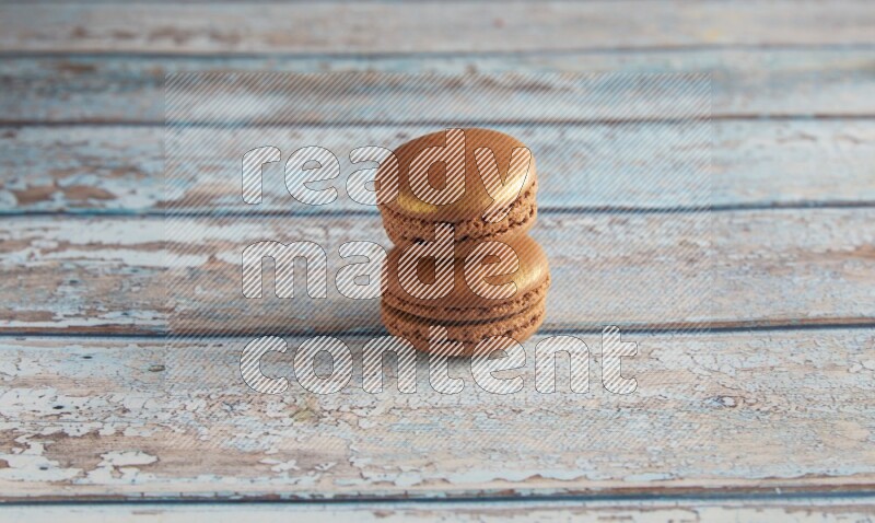 45º Shot of two Brown Coffee macarons on light blue wooden background