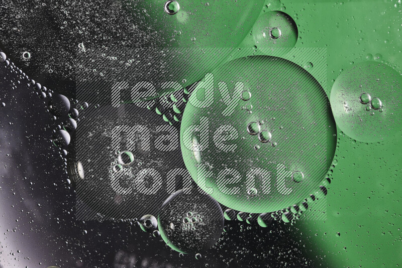 Close-ups of abstract oil bubbles on water surface in shades of black and green