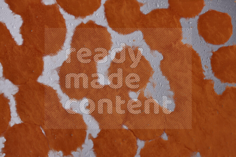 Close-ups of abstract orange paint droplets on the surface