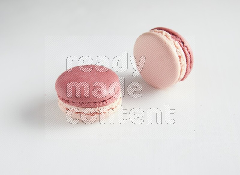 45º Shot of two Pink Litchi Raspberry macarons on white background