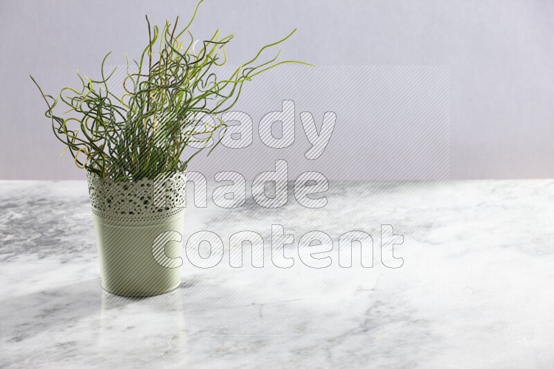 Artificial plant in green decorative pot on grey marble background