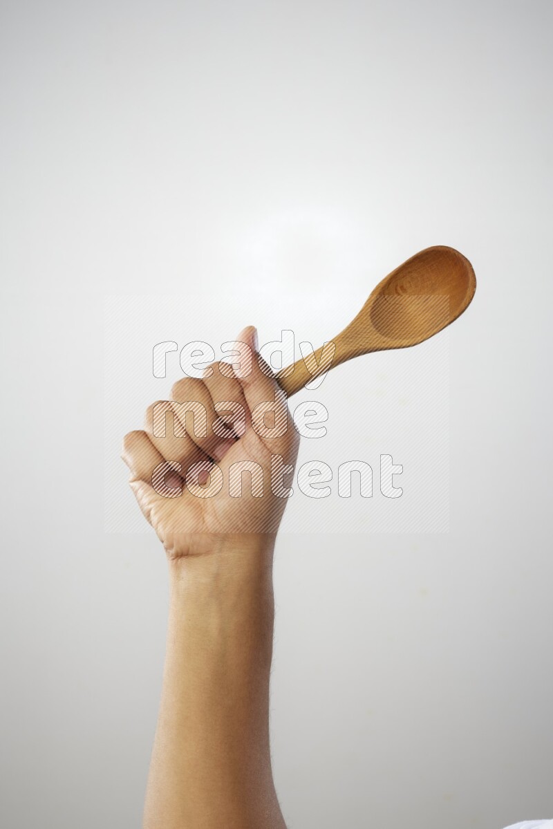 Male Hand Holding Wooden spoon on white background