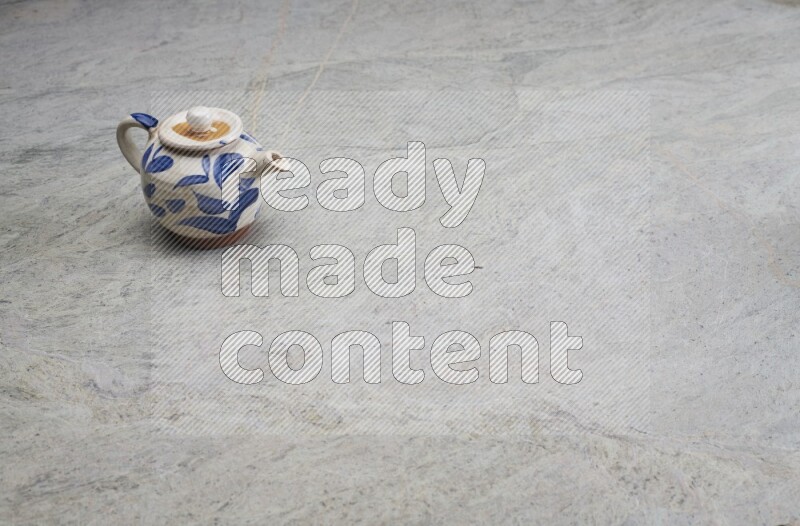 A pottery teapot on grey marble background