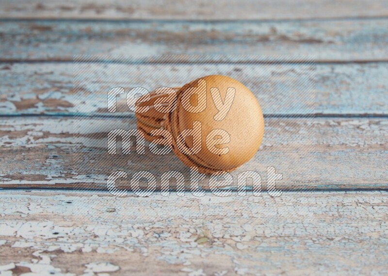 45º Shot of of two assorted Brown Irish Cream, and Brown Maple Taffy macarons  on light blue background