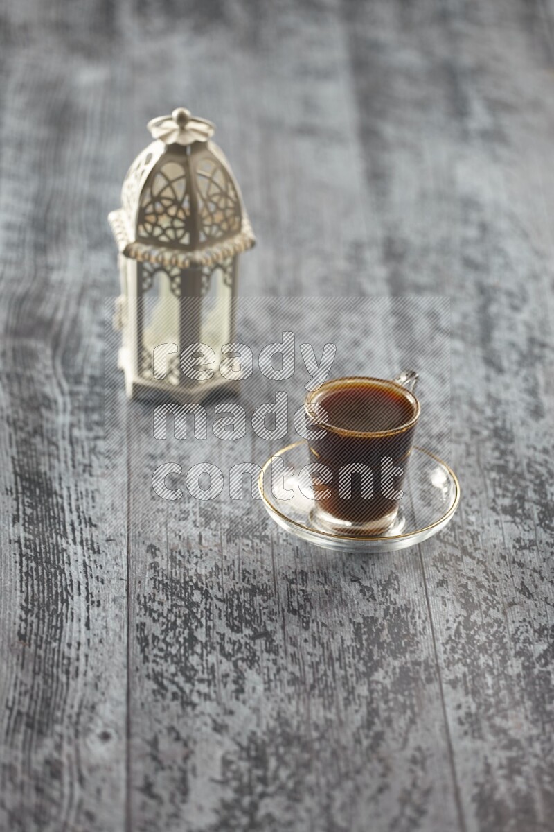 A white lantern with different drinks, dates, nuts, prayer beads and quran on grey wooden background