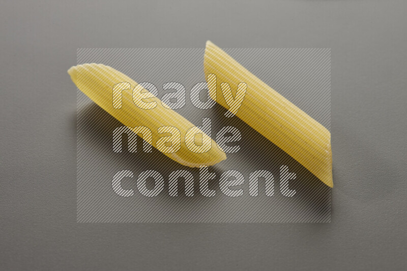 Penne pasta on grey background