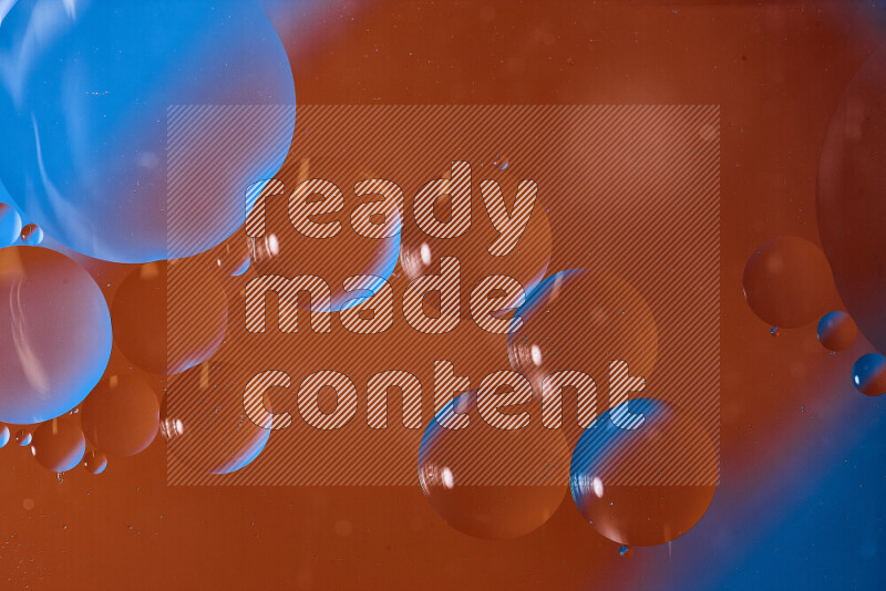 لقطات مقربة لفقاعات من الزيت على سطح الماء باللون الأزرق والبرتقالي