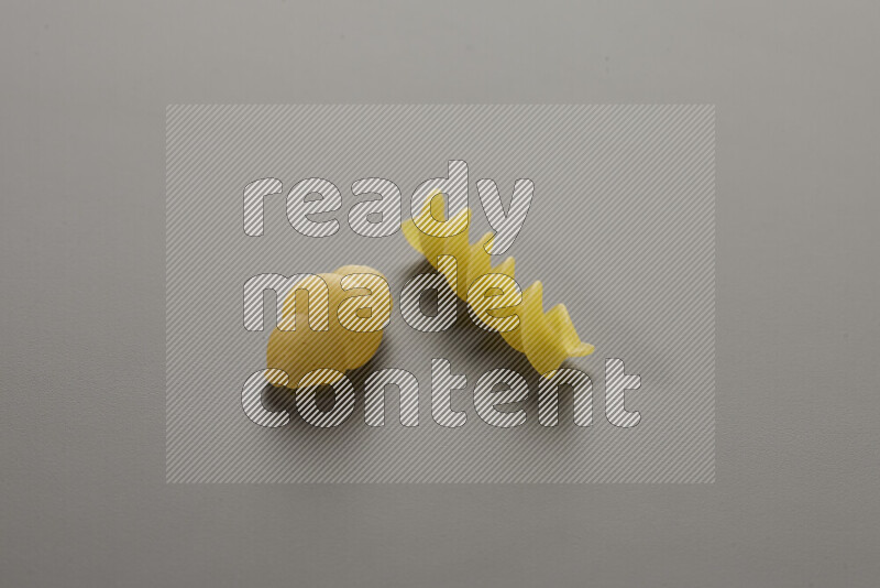 Snails pasta with other types of pasta on grey background