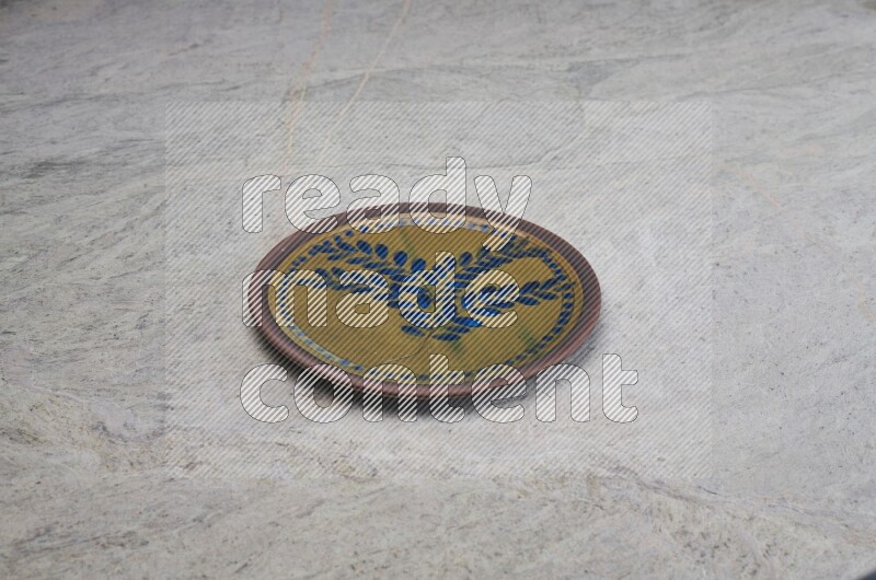 A decorative pottery plate on grey marble background