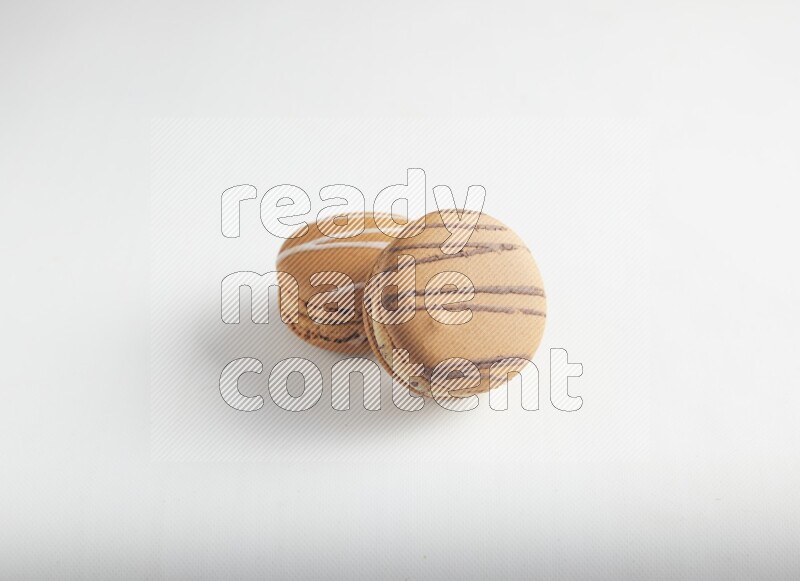 45º Shot of of two assorted Brown Irish Cream, and light brown  Almond Cream macarons on white background