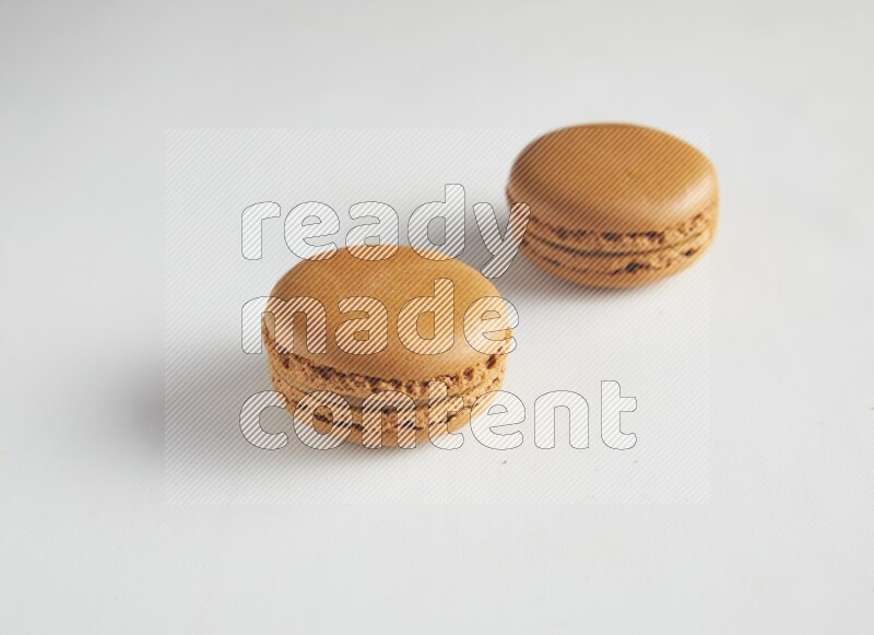 45º Shot of two Brown Maple Taffy macarons on white background